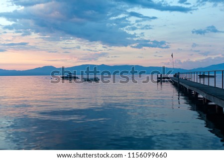 Boat pier and lake surface during early morning sunrise over Lake Tahoe in California
