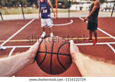Keep playing. Close up of man holding ball while playing basketball with friends outdoors