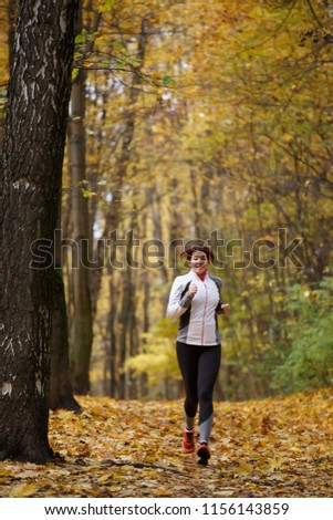 Image of sports brunette on morning run in autumn