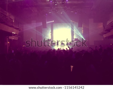 Blur image of concert, Celebration party, light and sound entertainment, having fun on holidays, new year, christmas party. abstract photo use for background. Crowd people dance in night-club.