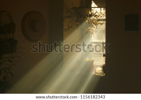 Rays of light coming from a window in an old country house. Heavenly light in a dusky old house. Royalty-Free Stock Photo #1156182343