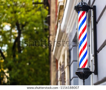 Barber shop pole. Logo of the barbershop, symbol. Barbershop pole, retro. Copy space. Old fashioned vintage barber shop pole. A classic barber logo. Bearded man.
