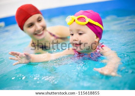 One year  baby girl at his first swimming lesson wiht mother