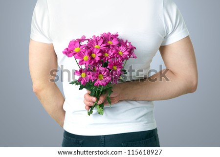 Man hiding a bouquet of flowers behind his back. unrecognizable