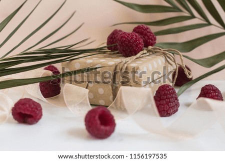modern gift wrapping. doted craft gift. present box with copy place and raspberry on a white background 