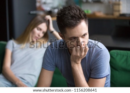 Upset frustrated boyfriend thinking of family conflicts after fight with girlfriend, sad thoughtful husband disappointed in bad marriage relationships tired or problems and disagreements with wife Royalty-Free Stock Photo #1156208641