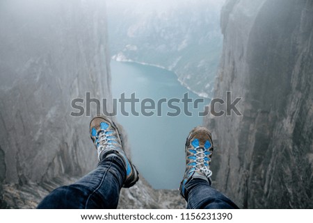 Feet over the cliff with water
