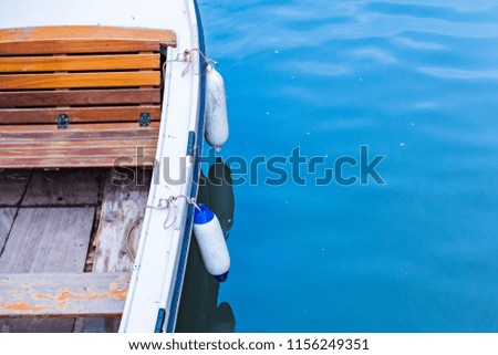 In the blue sea of the quay an empty transport wooden boat.
