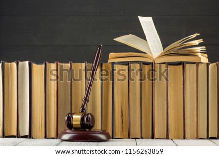 Legal Law concept - Open law book with a wooden judges gavel on table in a courtroom or law enforcement office. Copy space for text