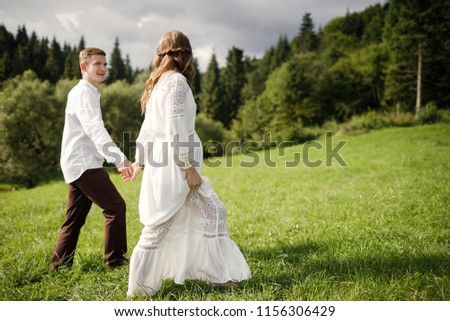 Happy pregnant couple hugging in nature.  Happy bride and groom are waiting for a baby. Loving family, husband and wife in in mountains.