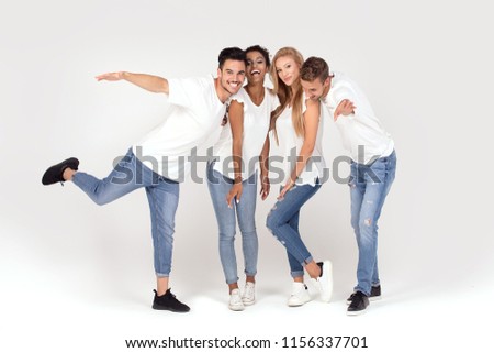 Group of young multi-ethnic attractive people wearing white shirts, smiling and having fun together, posing in studio.