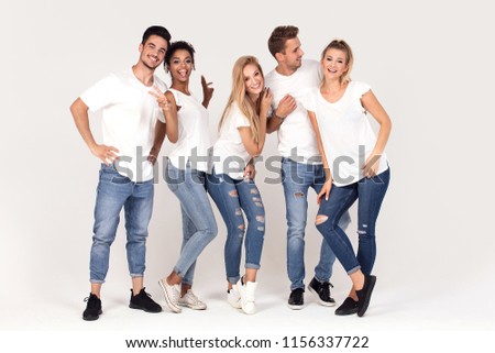 Group of young multi-ethnic attractive people wearing white shirts, smiling and having fun together, posing in studio.