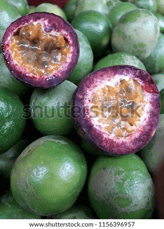 Passion fruit are on green pile of lemon.