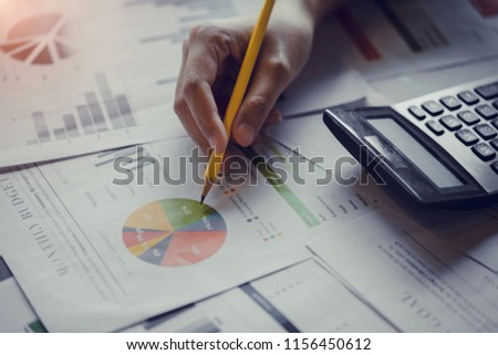 Close up hand of businesswoman or accountant working with calculator to calculate business data, and accountancy document. Business financial and accounting concept. Royalty-Free Stock Photo #1156450612