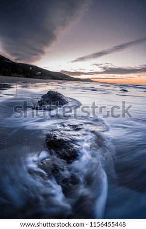Waves Washing over Rocks at Beach at Sunrise