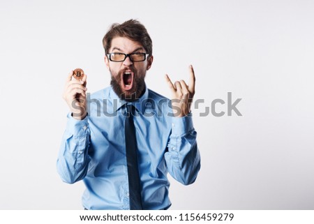 surprised man with open mouth gestures with hands, coin                             
