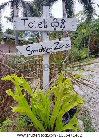 Wooden sign isolated toilet and smoking zone on nature backgroud.