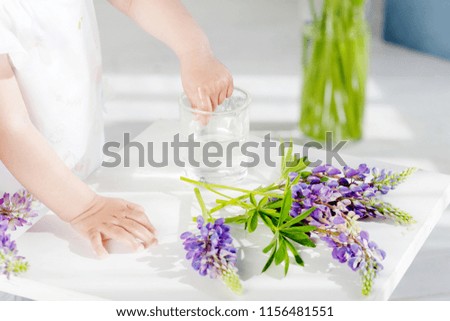 Little girl plays with  bouquet of flowers. Close up picture