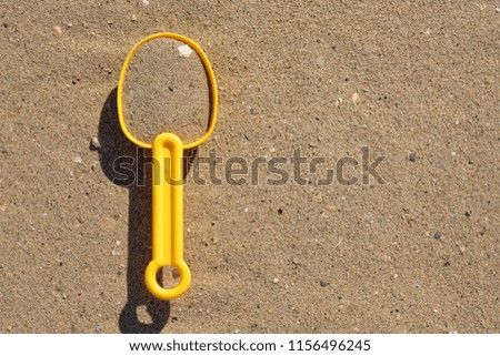 Plastic toy spade with sea sand and shells 