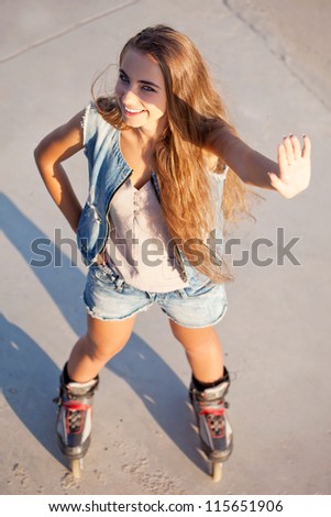 happy girl on roller skates standing on the floor, top point of view