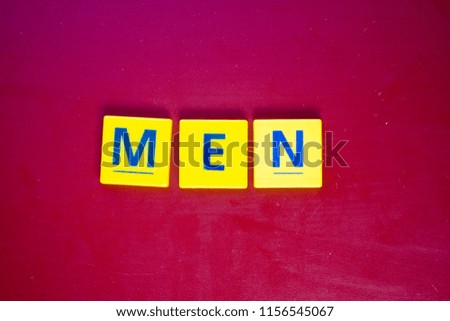 Yellow plastic word men on a wooden background