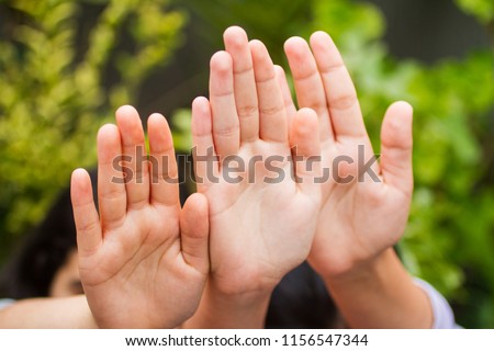 Selective focus on a palm of teenage girls with long thin fingers, looking back of the camera, extending arm, gesturing stop sign with their hands, expressing rejection or warning