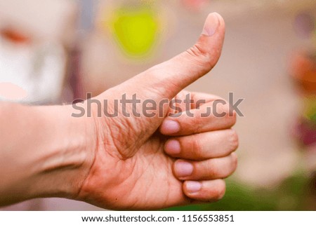 successful man pointing thumb up; portrait of cheerful smiling man pointing up approving, yes, ok, good, thumb up gesture; teen age young adult model