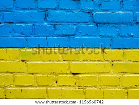 the flag of Ukraine is painted on the old brick wall. Symbol of Ukraine's Independence.