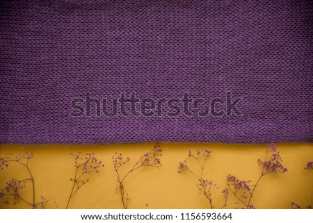 Purple knitted texture. purple clothes and purple dry yellow flowers and leaves. autumn concept.