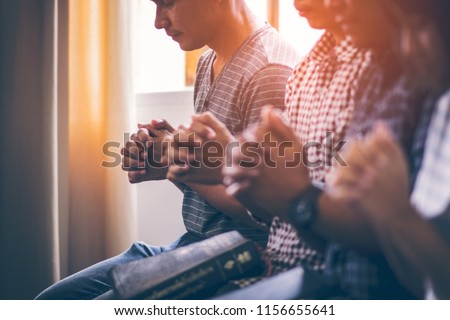 Asian Christian groups sitting within the Church Catholic. They clasped hands and closed his eyes and prayed for blessings from God. A pale sun shone in a place of worship. Everyone smiled happily. Royalty-Free Stock Photo #1156655641
