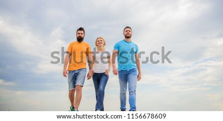 Friendship tested for years. United threesome true friends. Men and woman walks dramatic cloudy sky background. True friendship grow with destiny obstacles. United group purposefully moves forward.