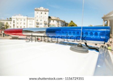 Signal lamp on police car near the background of a fragment of the city street. (Security, help, law - concept)