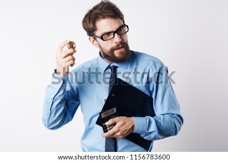business man with glasses and documents in his hands holds a coin                           