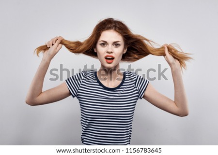 a woman touches her hair with her hands                            