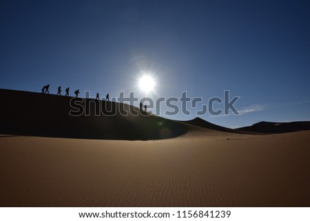 People Walking off a Dune , Sand Dune and Blue Sky , Sunshine and golden Sand Textur