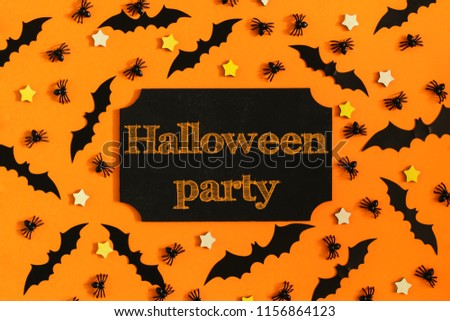 On an orange background, many ornamental spiders, small stars and bats are laid out. In the center there is a sign with the inscription Halloween party. Bright photo.