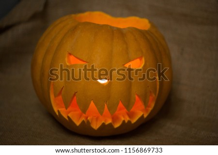 Halloween symbol jack-o-lantern. Scary carved pumpkin with burning candles. Copy space. 