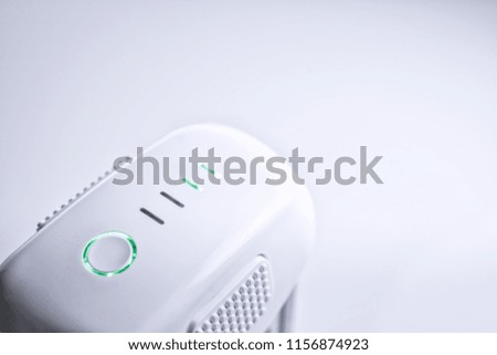 A white drone smart Battery pack with LED indicator lights ON, on white isolated background