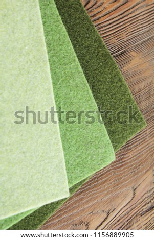 Cloth. Three shades of green on a wooden background
