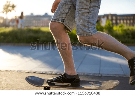 side view of young man riding skateboard fast speed in the city park