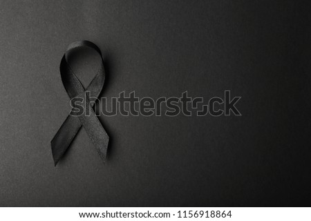 Black ribbon and space for text on dark background, top view. Funeral accessory Royalty-Free Stock Photo #1156918864
