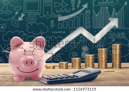Piggy bank, calculator and coins on wooden Royalty-Free Stock Photo #1156973119