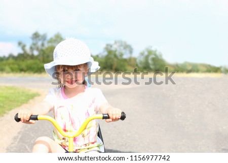 Joyful happy child on a bike for a walk on the street
