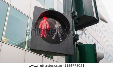 red traffic light for a pedestrian. sign for walkers to stop