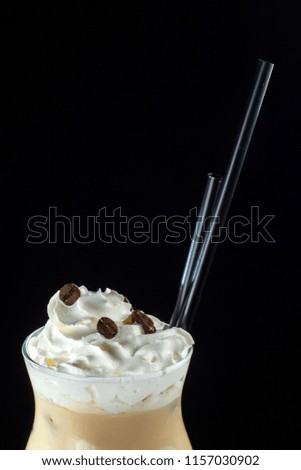 Ice coffee on a black background. In a beautiful glass. Clouse-up.