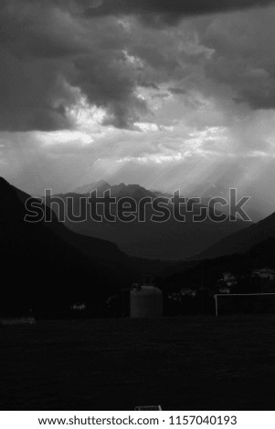 the rays of the sun falling through the clouds falling on the misty peaks of the mountains