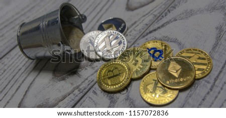  golden bitcoin and other crypto currency in toy metal bucket