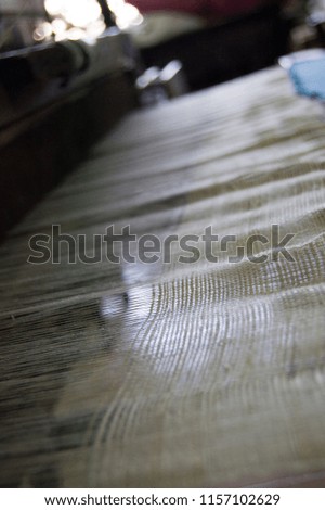 Closeup of cloth being woven on a large loom. Photo taken in Chiang Mai, Thailand.