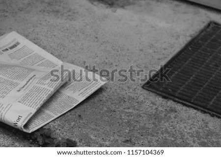 Newspaper laying on the ground, nostalgic and melancholic atmosphere. Royalty-Free Stock Photo #1157104369