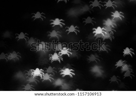 defocused white spiders silhouette ghosts on black for halloween background - holidays, decoration and party concept